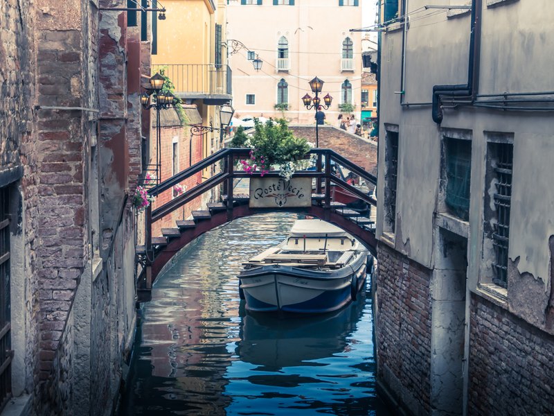 Boot onder een brug in Venetië, Italië.